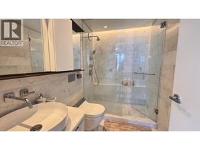 Vancouver apartment for rent - A bathroom with a marble tile shower and a glass door.