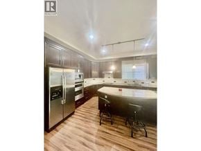 Coquitlam apartment for rent - A modern kitchen with dark wood floors and stainless steel appliances.