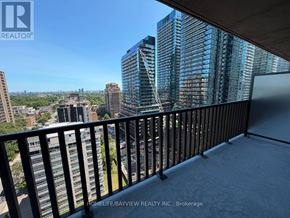 Toronto (Mount Pleasant West) condo for rent - A balcony overlooks a cityscape with a view of a tall building.