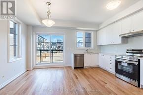Mississauga (East Credit) townhouse for rent - A kitchen with white cabinets and a wooden floor.