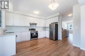 Mississauga (East Credit) townhouse for rent - A kitchen with white cabinets and a wooden floor.