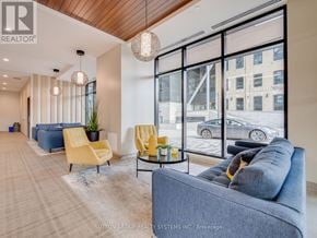 Kitchener condo for rent - A living room with a grey couch, yellow chairs, and a glass table.