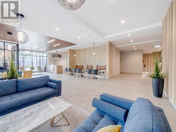 Kitchener condo for rent - A modern living room with a large blue sofa and a wooden floor.