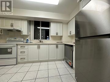 Toronto (Willowdale East) condo for rent - A kitchen with white cabinets and a stainless steel refrigerator.