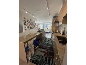 Surrey townhouse for rent - A kitchen with a long counter and a fridge on the left.
