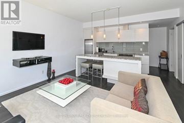 Toronto (Waterfront Communities) condo for rent - A modern living room with a glass coffee table and a television mounted on the wall.