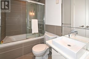 Toronto (Waterfront Communities) condo for rent - A white toilet sits next to a white sink in a bathroom.