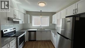 Hamilton apartment for rent - A modern kitchen with stainless steel appliances and white cabinets.