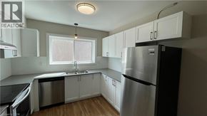 Hamilton apartment for rent - A kitchen with white cabinets and a stainless steel refrigerator.