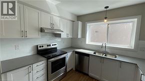 Hamilton apartment for rent - A kitchen with white cabinets and a stove top oven.