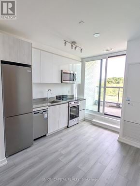 Toronto (Downsview-Roding-Cfb) condo for rent - A kitchen with white cabinets and a stainless steel refrigerator.