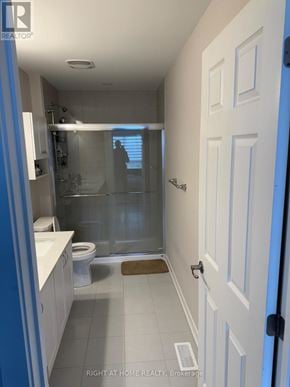 Ottawa townhouse for rent - A bathroom with a white door and a glass shower stall.