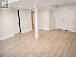 Oshawa (Taunton) apartment for rent - A spacious room with white walls and wooden flooring.