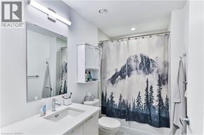 Guelph condo for rent - A bathroom with a mountain scene shower curtain.