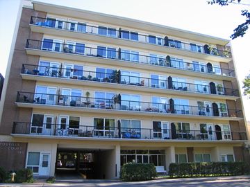 Ottawa apartment for rent - Apartment building with balconies and a garage entrance.