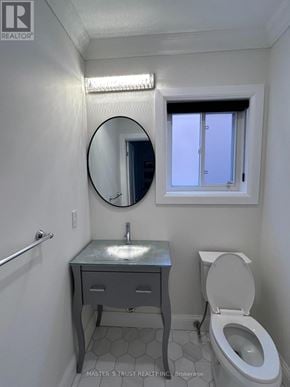 Richmond Hill (Westbrook) apartment for rent - A bathroom with a toilet, sink, and mirror.