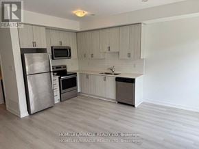 Vaughan (Vaughan Grove) townhouse for rent - A kitchen with a refrigerator, microwave, oven, and sink.
