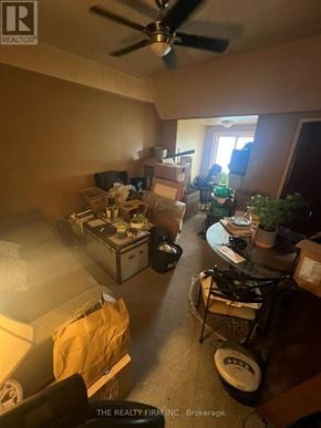London East (East F) fourplex for rent - A messy room with a fan and a sign that says "The Realty Firm, Inc., Brokerage".