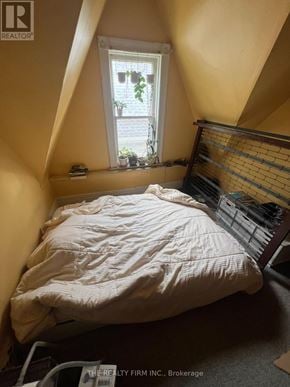 London East (East F) fourplex for rent - A bed with a white comforter sits in a room with a window.
