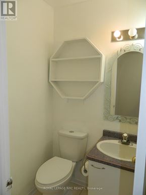 St. Catharines (Carlton/Bunting) townhouse for rent - A white toilet sits next to a sink in a bathroom.