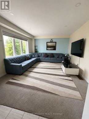 Southgate apartment for rent - A living room with a grey couch and a flat screen TV mounted on the wall.
