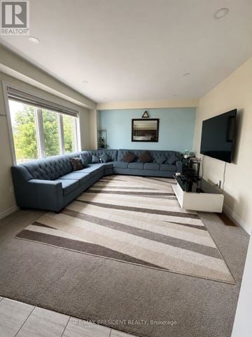 Southgate apartment for rent - A living room with a grey couch and a flat screen TV mounted on the wall.