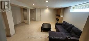 Oshawa (Centennial) apartment for rent - A living room with a couch, coffee table, and a large window.