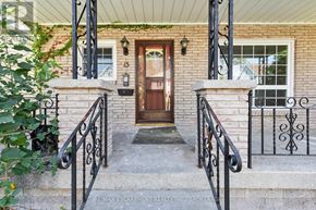 Welland (Prince Charles) multi-family for rent - A house entrance with a brown door and black metal railings.