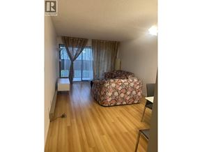 Richmond apartment for rent - A room with a floral sofa and a window with curtains.