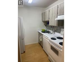 Richmond apartment for rent - A kitchen with a white stove top oven and a white refrigerator.