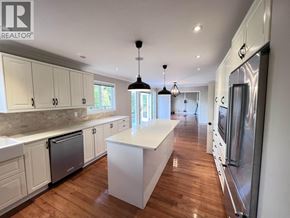 Coquitlam apartment for rent - A modern kitchen with wooden floors and white cabinetry.
