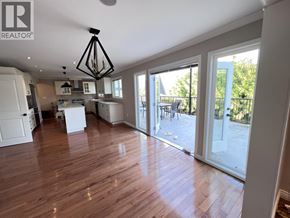 Coquitlam apartment for rent - A large open space with wooden floors and a kitchen area.