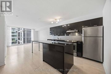 Toronto (Bayview Village) condo for rent - A modern kitchen with stainless steel appliances and a large island.