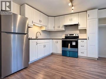 Brantford apartment for rent - A kitchen with white cabinets and a stainless steel refrigerator.