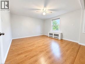 Brantford apartment for rent - A room with wooden flooring and a window with a view of trees.