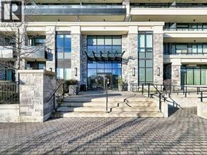 Markham (Unionville) condo for rent - A building with a stone facade and a glass entrance.