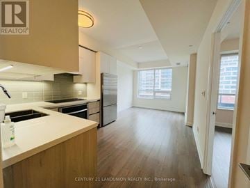 Markham (Unionville) condo for rent - A kitchen with wooden cabinets and a white countertop.