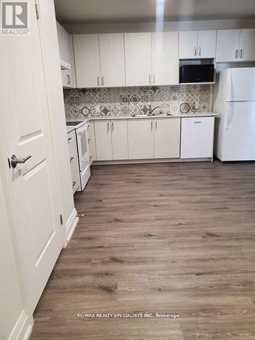 Hamilton (Beasley) condo for rent - A kitchen with white cabinets and a white fridge.