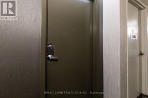 Toronto (Moss Park) condo for rent - A door with a handle and a sign on the wall.