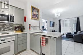 Toronto (Moss Park) condo for rent - A modern kitchen with a stove top oven, microwave, and a sink.