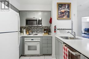 Toronto (Moss Park) condo for rent - A kitchen with a refrigerator, microwave, oven, and sink.