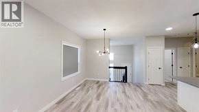 Grande Prairie apartment for rent - A spacious room with a large window, hardwood floors, and a chandelier.