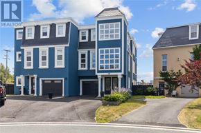 St. John's apartment for rent - A blue two-story building with a garage is in front of a smaller beige building.