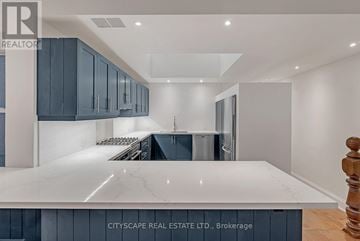 Toronto (Niagara) townhouse for rent - A modern kitchen with dark blue cabinets and a white marble countertop.
