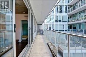 Toronto (Waterfront Communities) condo for rent - A long hallway with glass railings and a bench.