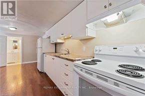 Hamilton (Berrisfield) apartment for rent - A white stove is in a kitchen with white cabinets and a white range hood.