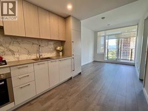 Burnaby apartment for rent - A kitchen with white cabinets and a marble backsplash.