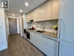 Burnaby apartment for rent - A kitchen with white cabinets and a marble backsplash.