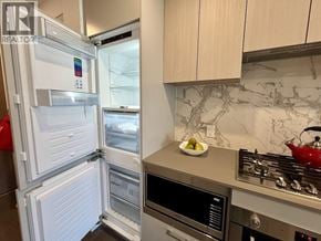 Burnaby apartment for rent - A modern kitchen with a white fridge, stove, and oven.