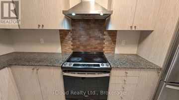 Ajax (South East) townhouse for rent - A modern kitchen with a stove top oven and wooden cabinets.